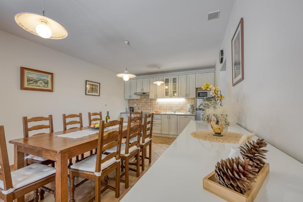 kuchnia i jadalnia ze stołem i krzesłami w obiekcie Villa Ladonja with Private Pool and Sauna w mieście Marasi