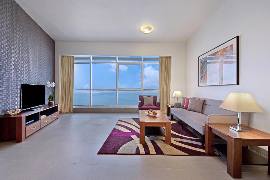 多哈White Square Curve Hotel & Suites的带沙发和电视的客厅