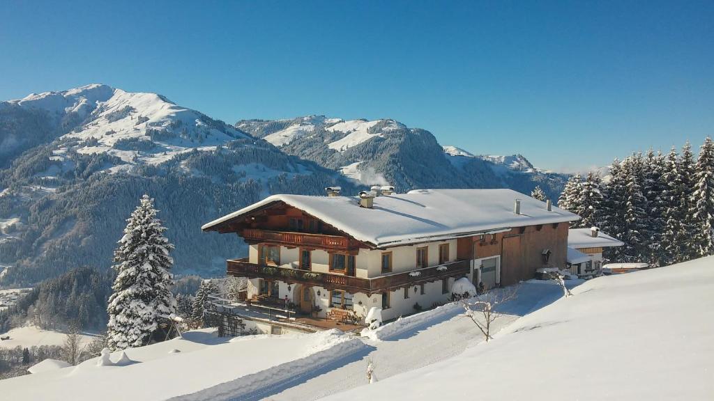 een huis bovenop een met sneeuw bedekte berg bij Hof Hamoos in Kitzbühel