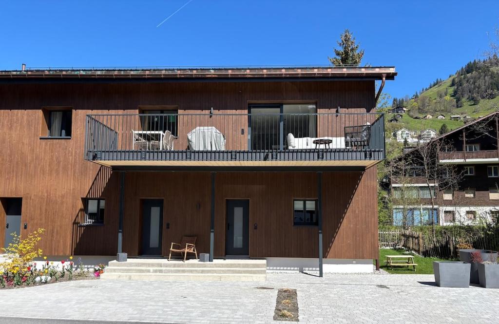 英格堡Genuine mountain holiday apartment in Engelberg的一座带椅子的阳台的建筑