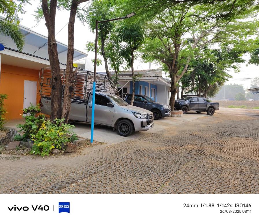 a car parked in a parking lot next to a house at ไดซูแนลรีสอร์ท in Ban Nong Song Hong