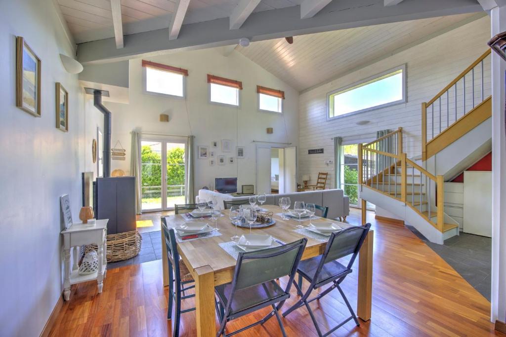 une salle à manger avec une table et des chaises dans l'établissement Les Coquelicots du Bassin - avec piscine privée, à Gujan-Mestras