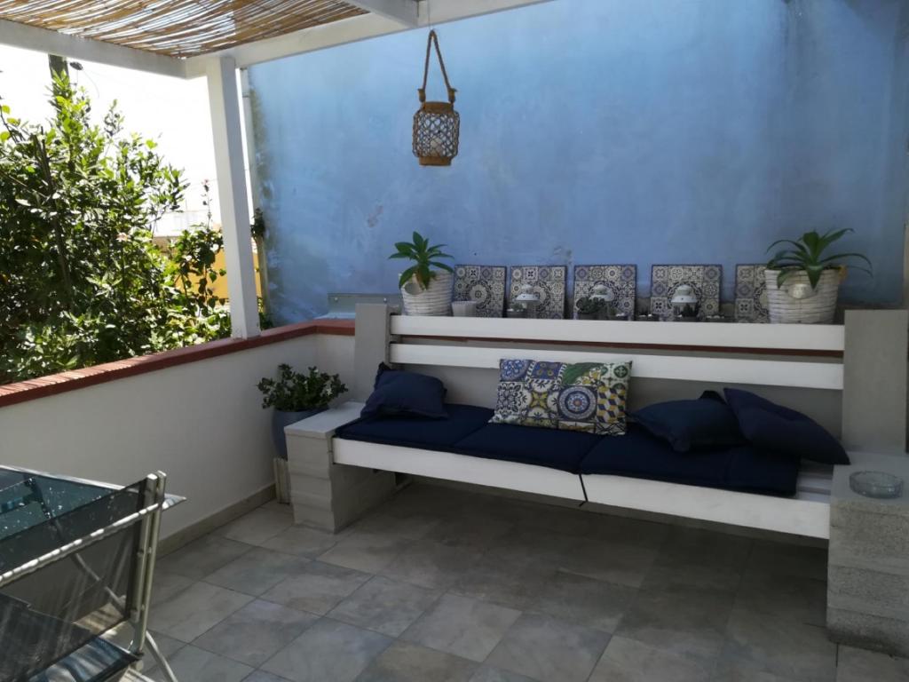 una panchina seduta su un balcone con piante di Villa Malsine a Marzamemi