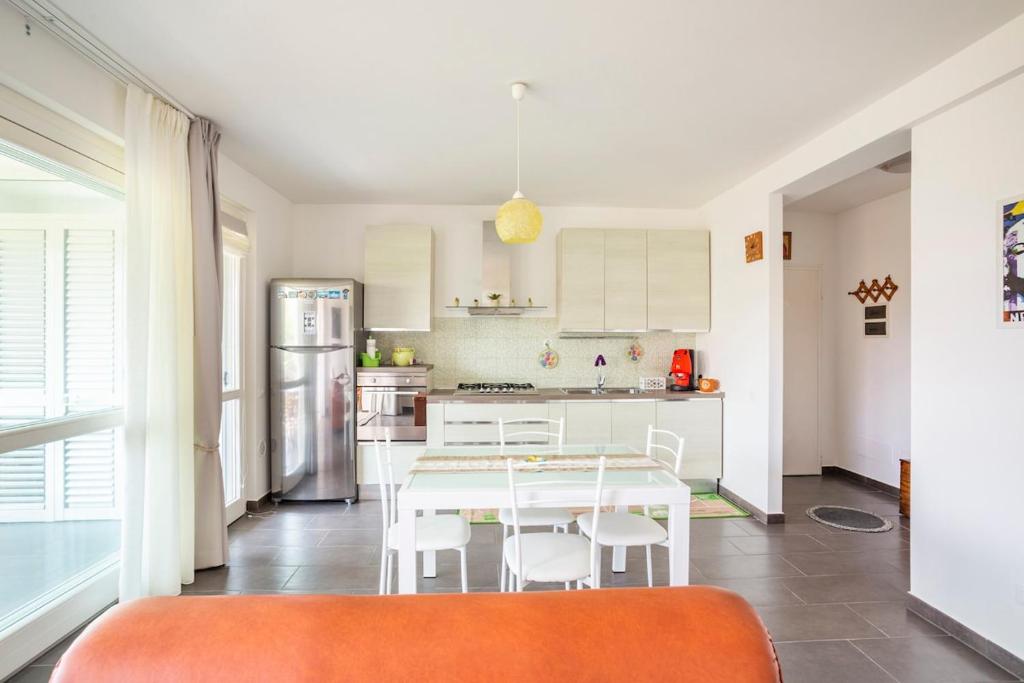 a kitchen with a white table and white chairs at Lovely Tiresia Apartment in Sperlonga