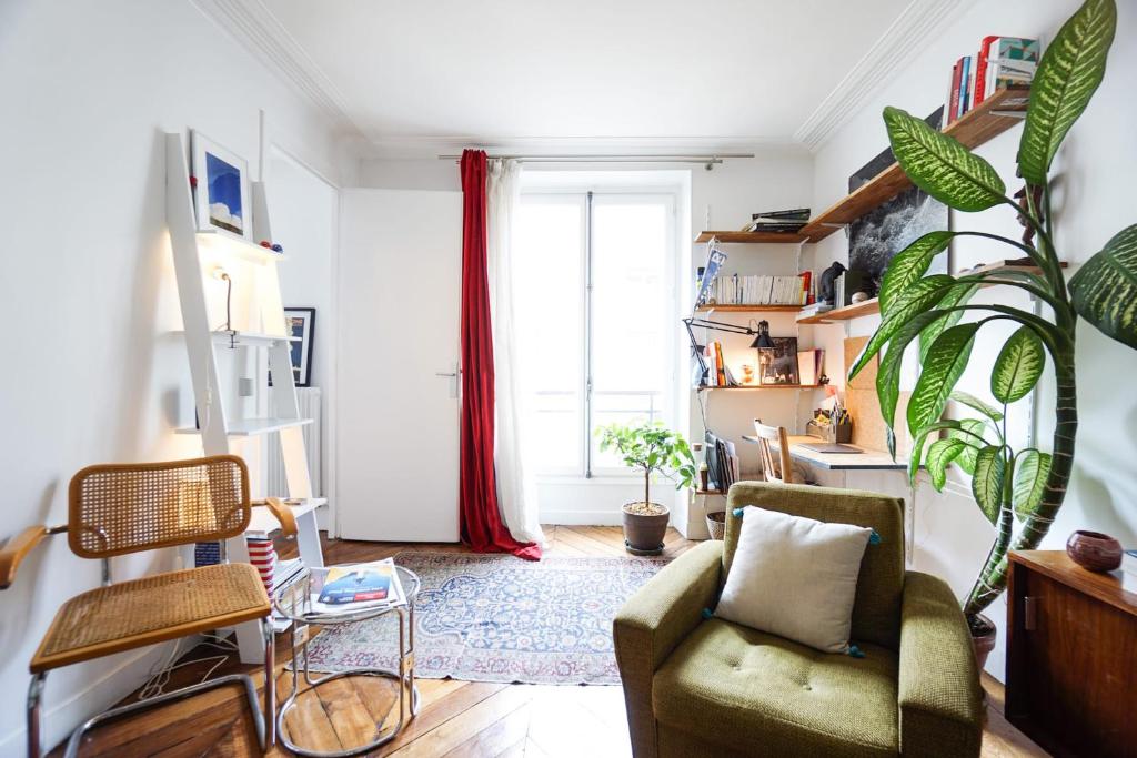 - un salon avec une chaise verte et une fenêtre dans l'établissement Beautiful Design Apt In Paris Near The Louvre, à Paris