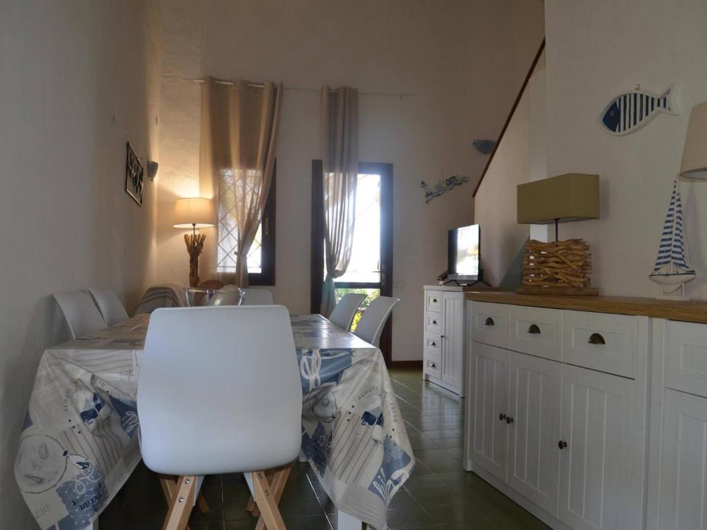 Zimmer mit einem Tisch und einem weißen Stuhl in der Unterkunft FPO CLA01 fantastic villa sul porto 6 posti letto in Porto Ottiolu