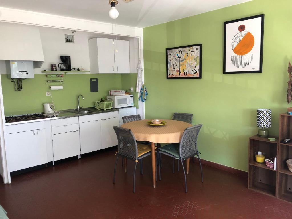 une cuisine avec une table et des chaises dans une pièce dans l'établissement Appartement F3 St Cyprien plage, à Saint-Cyprien