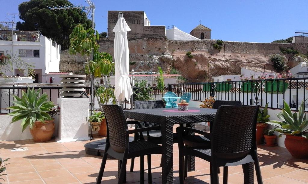 ミハスにあるCasa del Solのテーブル、椅子、パラソルが備わるバルコニー