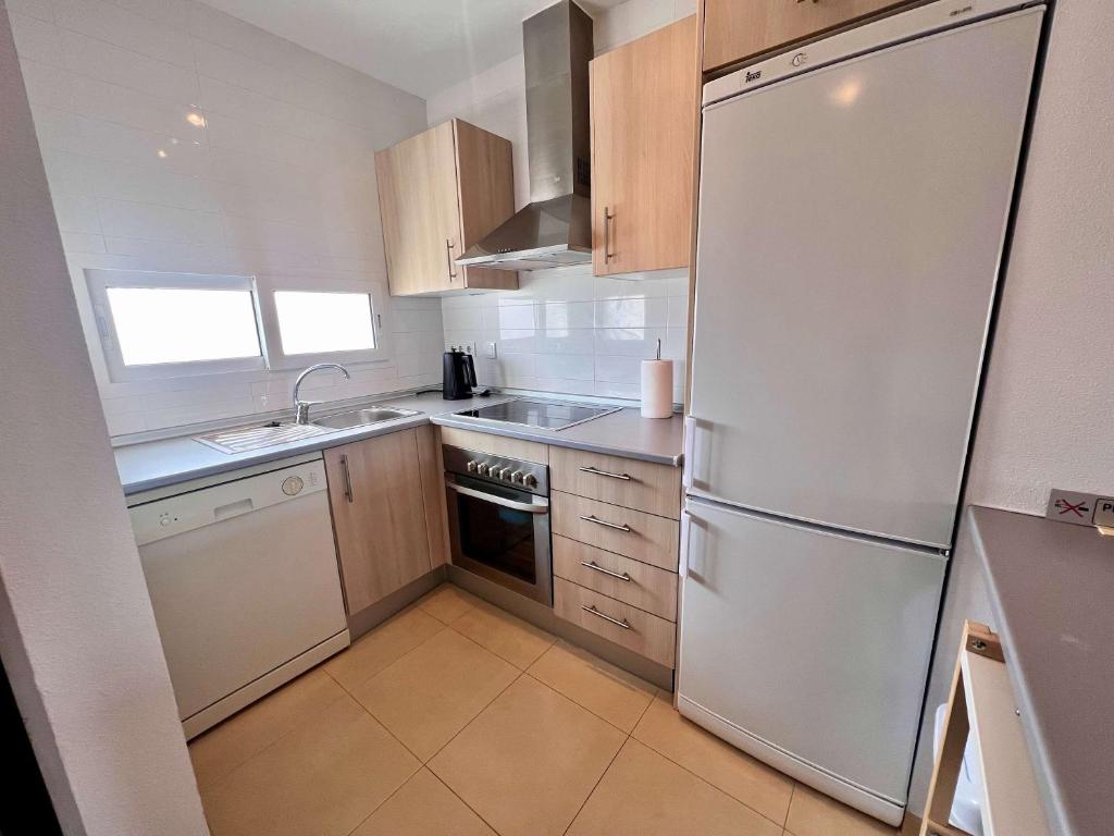 a kitchen with a white refrigerator and a sink at CONDADO DE ALHAMA PENTHOUSE 8 SV33 in Alhama de Murcia