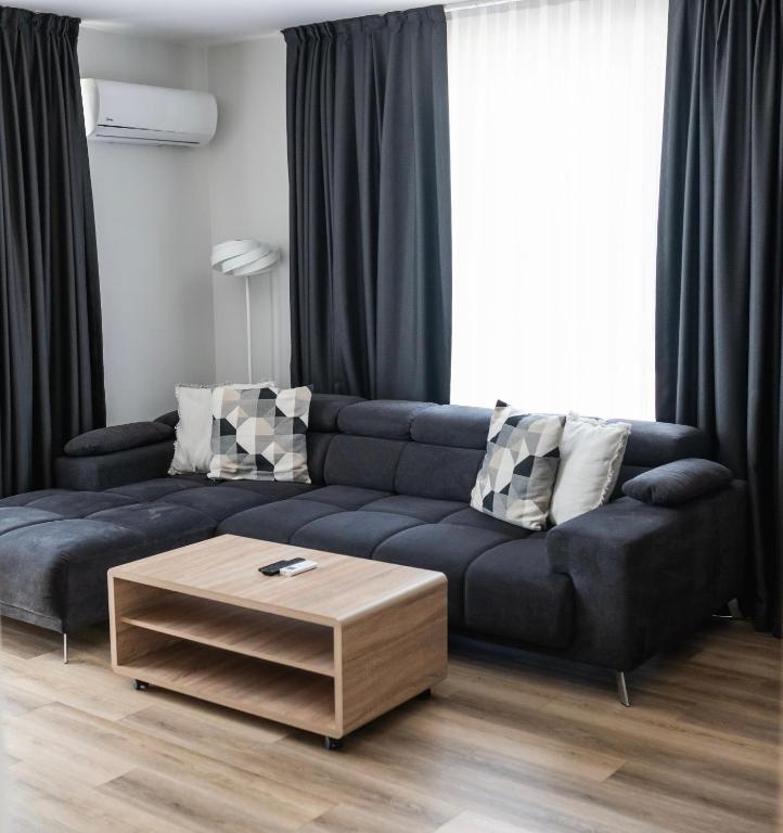 a living room with a blue couch and a coffee table at ТОП Апартаменти в Панорама Парк in Plovdiv