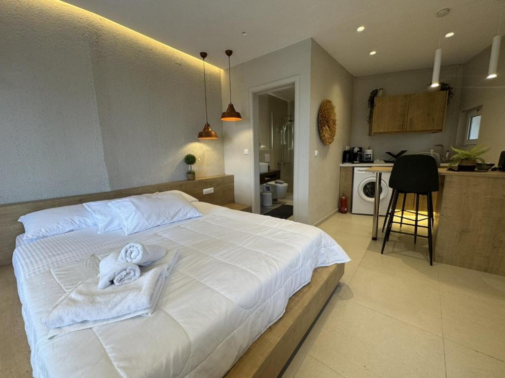 a bedroom with a white bed with towels on it at Eleftherias Suites - Near Beach Apartments in Marathi