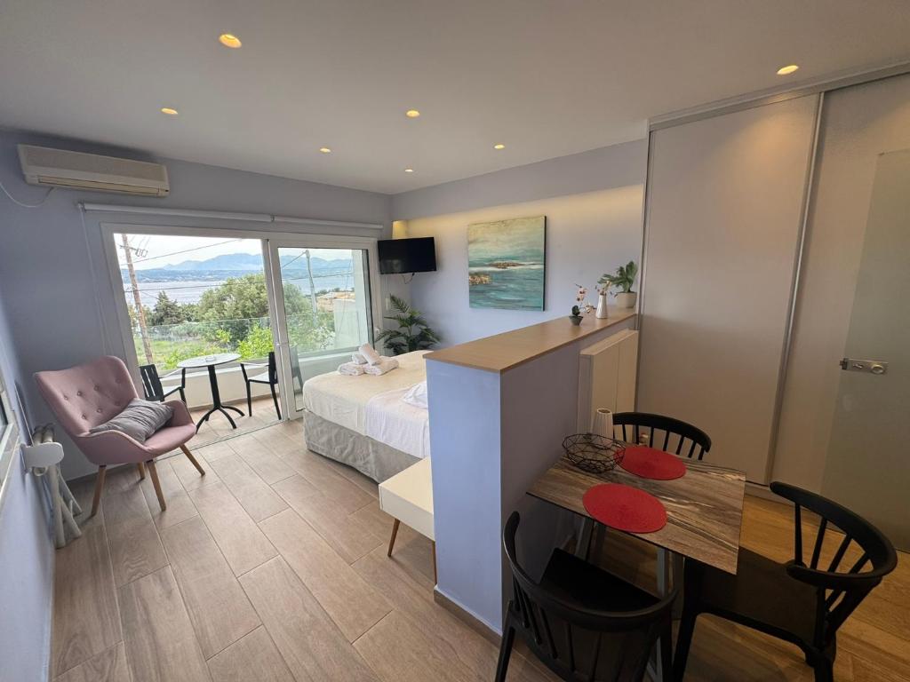 a bedroom with a bed and a table and chairs at Eleftherias Suites - Near Beach Apartments in Marathi