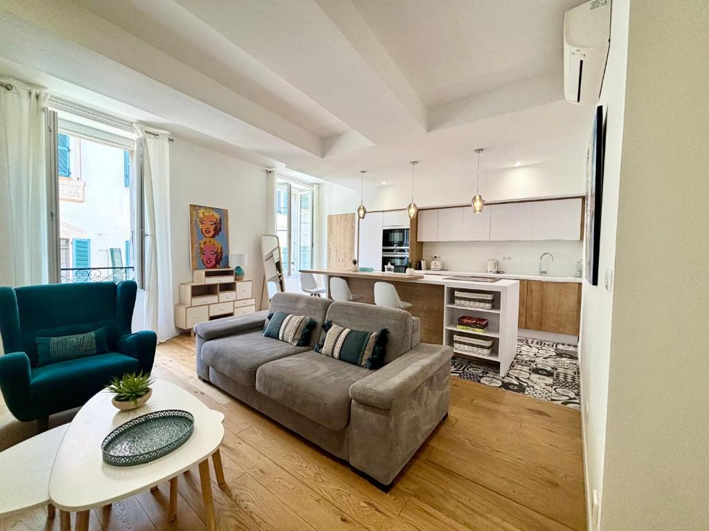 un salon avec un canapé et une cuisine dans l'établissement Casamea - Apt Élégant, Clim, Centre historique, à Ajaccio