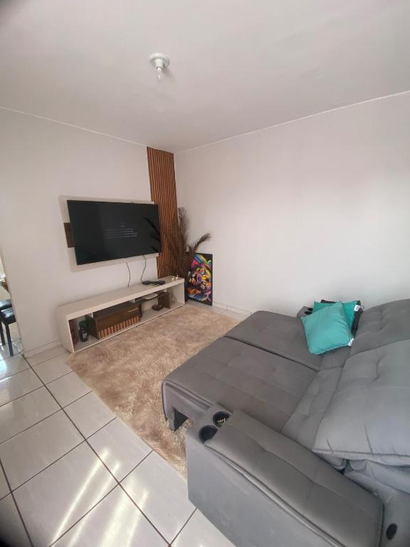 a living room with a couch and a flat screen tv at Goiás Brasília Confort in Valparaíso de Goiás