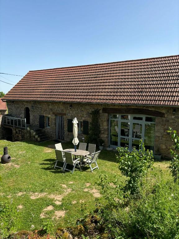 une table et des chaises devant une maison dans l'établissement Gentilhomme, à Donzy-le-National