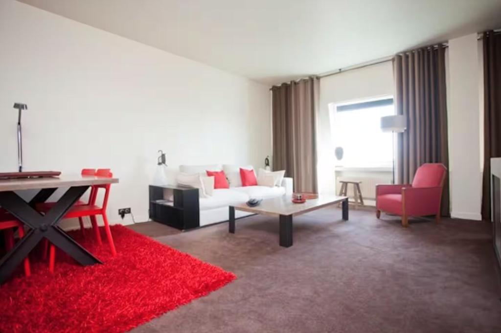 Una sala de estar con un sofá blanco y una alfombra roja. en Biarritz center Appartment, Beach & Golf Walking Tour, en Biarritz