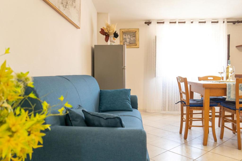 a living room with a blue couch and a table at La Caletta 5 in La Caletta
