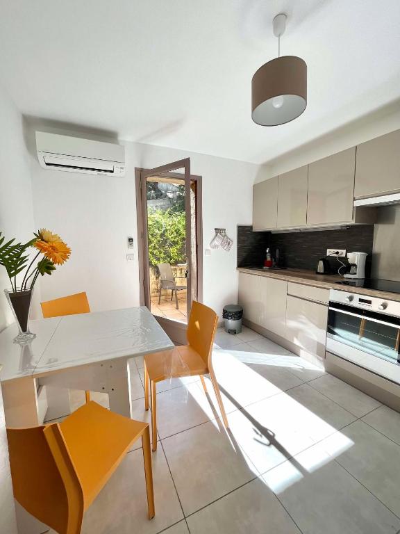 - une cuisine avec une table et des chaises blanches dans l'établissement Bel appartement au calme, à Santa-Reparata-di-Balagna