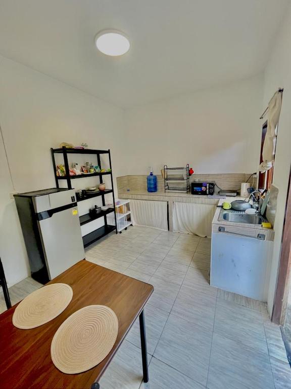 a kitchen with a table and a refrigerator and a sink at Unity coliving in Thong Sala