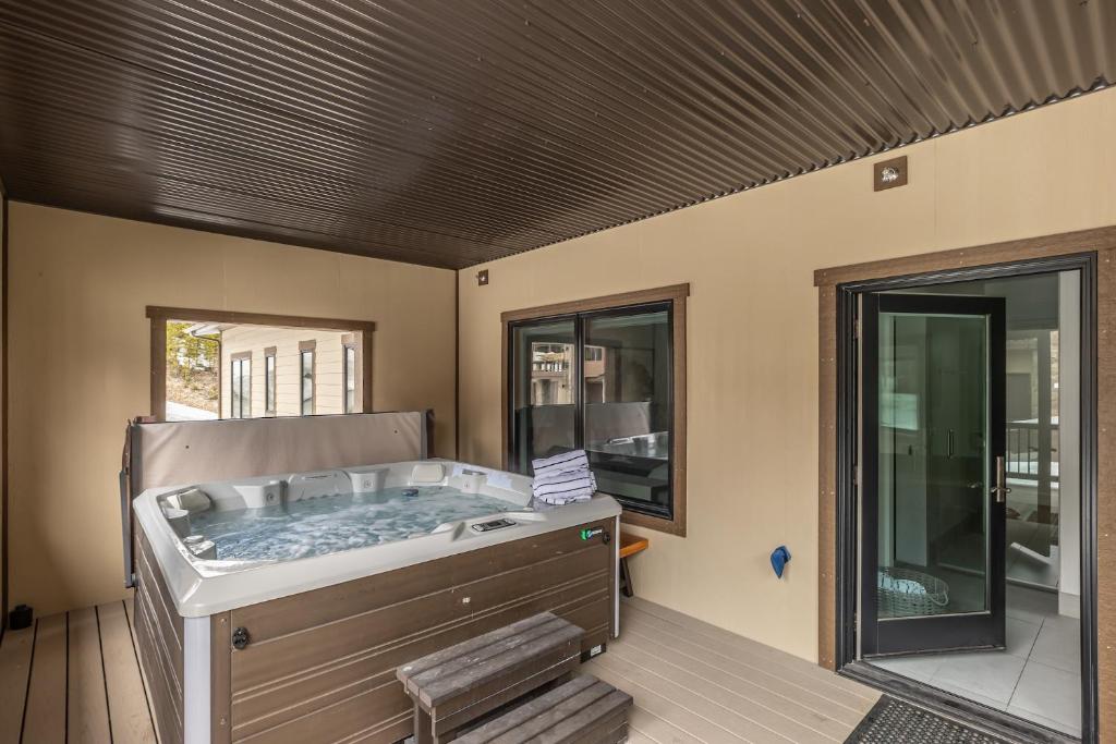 a hot tub in a room with a window at Beaverhead Condo - 5 Slalom #301 in Big Sky