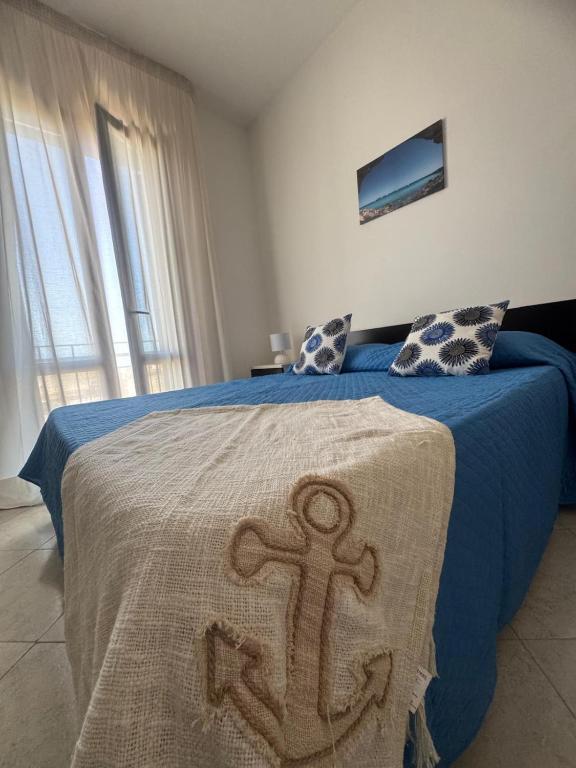 a bedroom with a bed with a blanket with an anchor on it at Casa Vacanze Tridente in Trapani