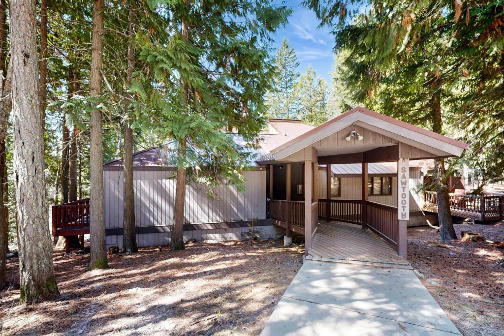 a house in the woods with a walkway at Whitefish Escape in Whitefish