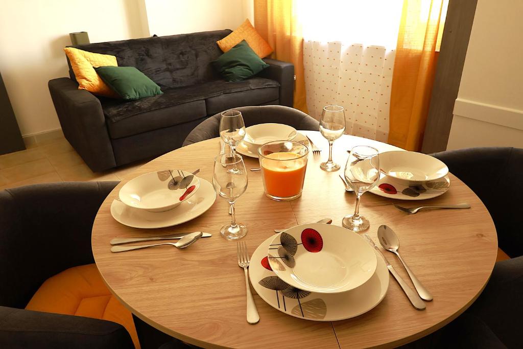 une table en bois avec des assiettes et des verres à vin dessus dans l'établissement AERO Nice, à Nice