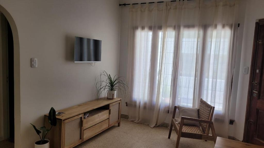 a living room with a tv and a table and a window at Departamento para dos personas, zona Basílica de Lujan in Luján