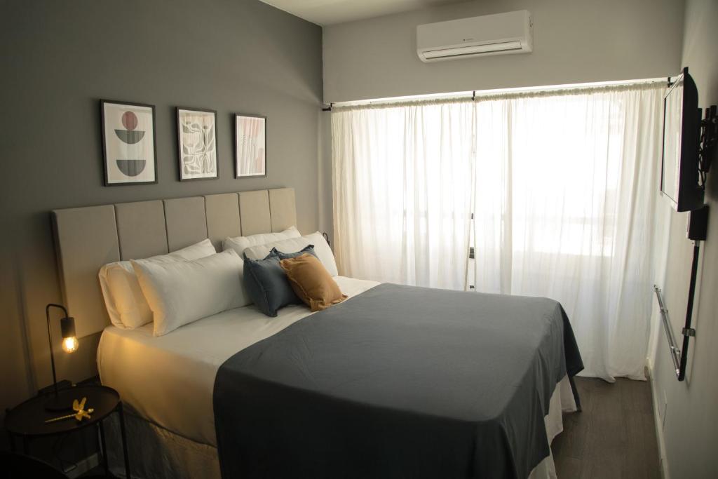 Un dormitorio con una cama grande con ventana. en El Misti Suites Buenos Aires, en Buenos Aires