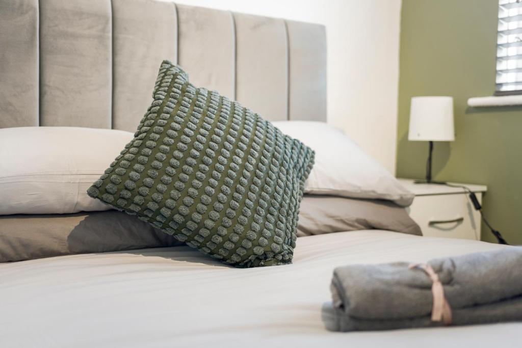 a green pillow sitting on top of a bed at Modern 4 bed & 4 En-suite City Centre with Parking in Southampton