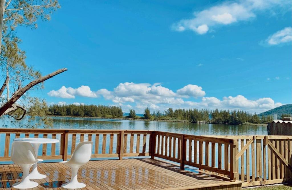 Casa de frente para lagoa com vista deslumbrante e ambiente tranquilo في لاغونا: سطح مع كراسي وإطلالة على البحيرة