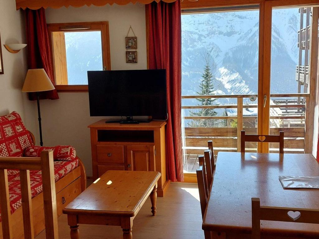 - un salon avec une télévision et une table à manger dans l'établissement 2 pièces cabine duplex 6 personnes - FR-1-636-14, à Orcières