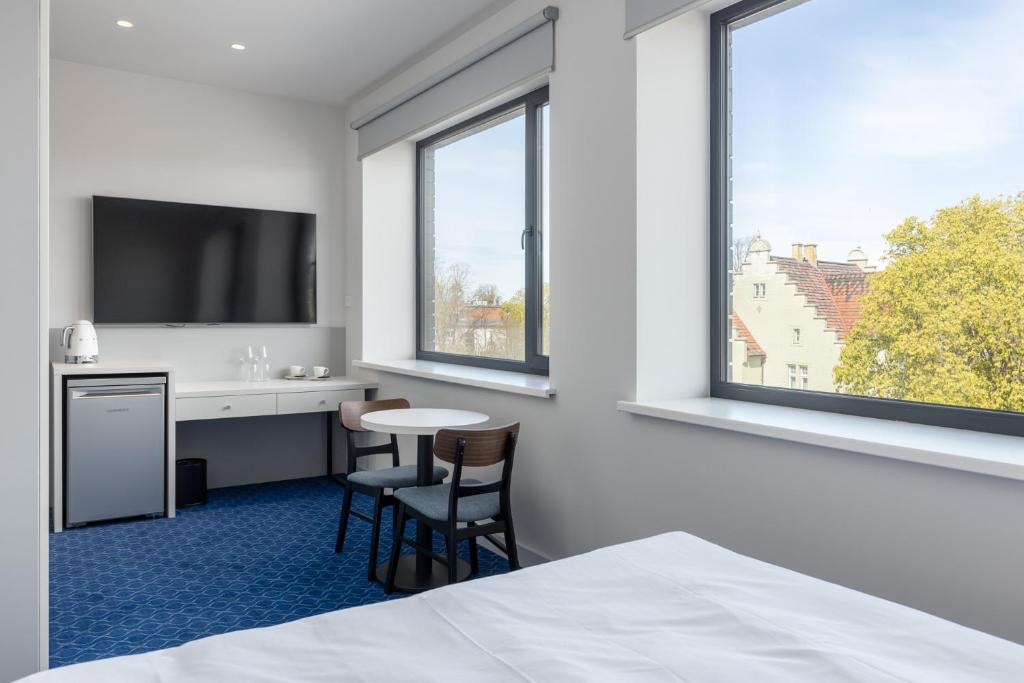a hotel room with a desk and a tv at Roze Kurmajas Hotel in Liepāja