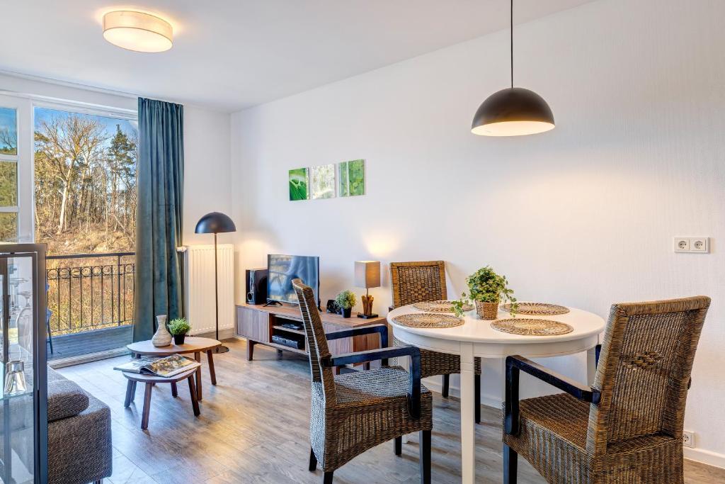 a living room with a table and chairs at Residenz am Balmer See - BS 55 mit Wellnessbereich in Balm