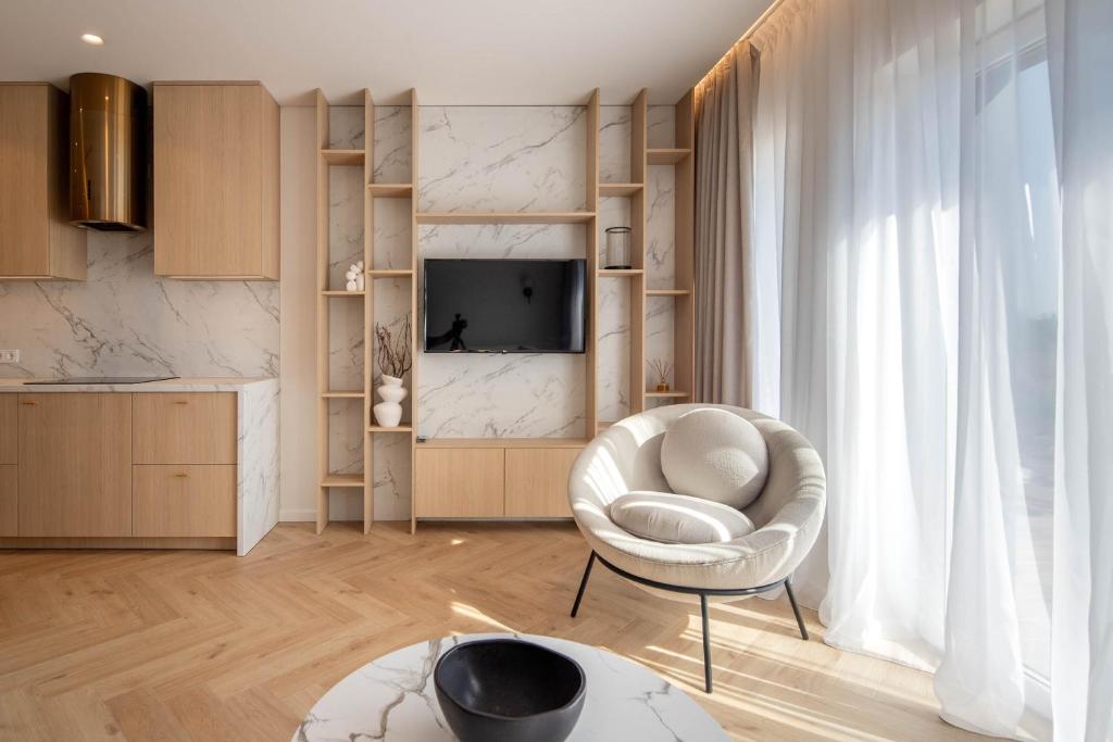 a living room with a white chair and a television at B-House in Palanga