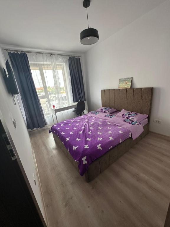 a bedroom with a purple comforter on a bed at Patris Place in Giroc