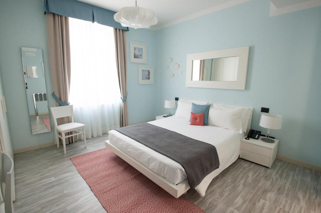 sypialnia z dużym białym łóżkiem i czerwonym dywanem w obiekcie Hotel Villa Bernt w Grado