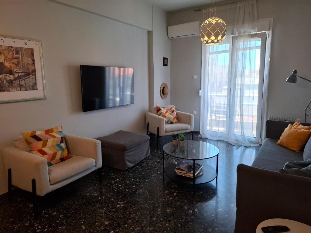 a living room with a couch and chairs and a tv at City Vibes "by Checkin" in Heraklio Town