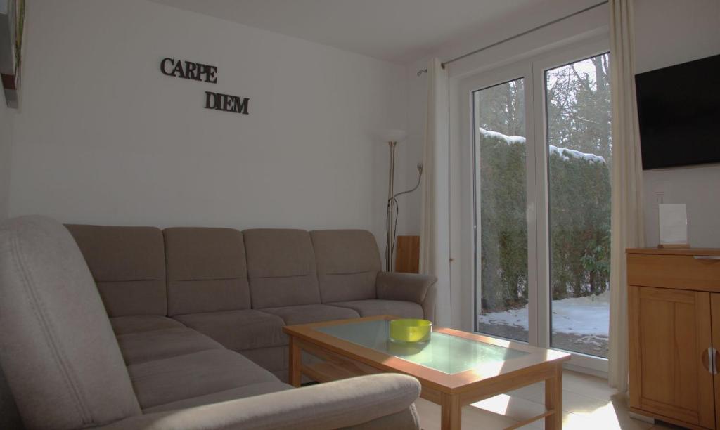 ein Wohnzimmer mit einer Couch und einem Couchtisch in der Unterkunft Ferienpark Rübezahl am Müggelsee, Haus 21 Efeu mit eigener Sauna, idealer Ort für Natur- und Erholungssuchende, für Radfahrer, Familien mit Kindern und Hundeliebhaber in Berlin
