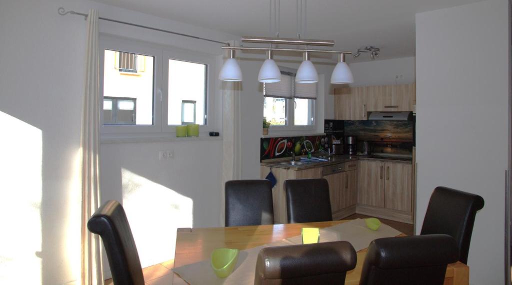 eine Küche und ein Esszimmer mit Tisch und Stühlen in der Unterkunft Ferienpark Rübezahl am Müggelsee, Haus 21 Efeu mit eigener Sauna, idealer Ort für Natur- und Erholungssuchende, für Radfahrer, Familien mit Kindern und Hundeliebhaber in Berlin