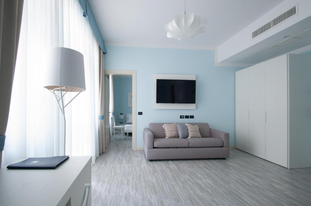 salon z kanapą i telewizorem w obiekcie Hotel Villa Bernt w Grado