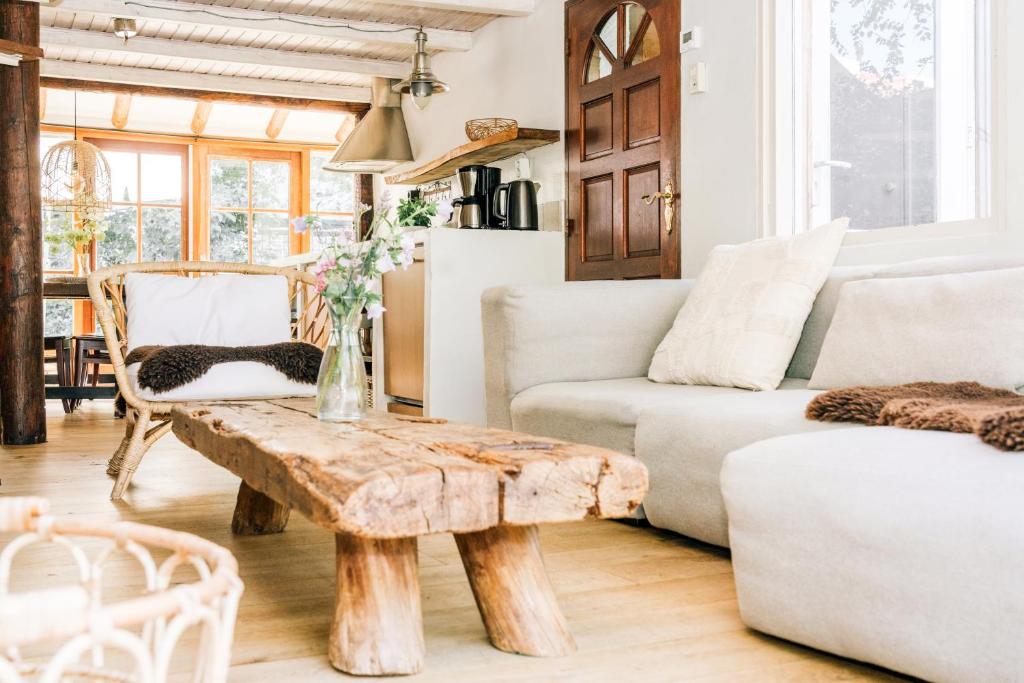 a living room with a table and a couch at "Albatros" Knus huisje op Texel in De Koog