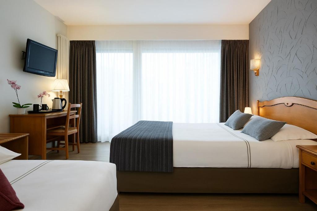 Postel nebo postele na pokoji v ubytování LOGIS HÔTEL, CHALETS et RESTAURANT LES CHATELMINÉS