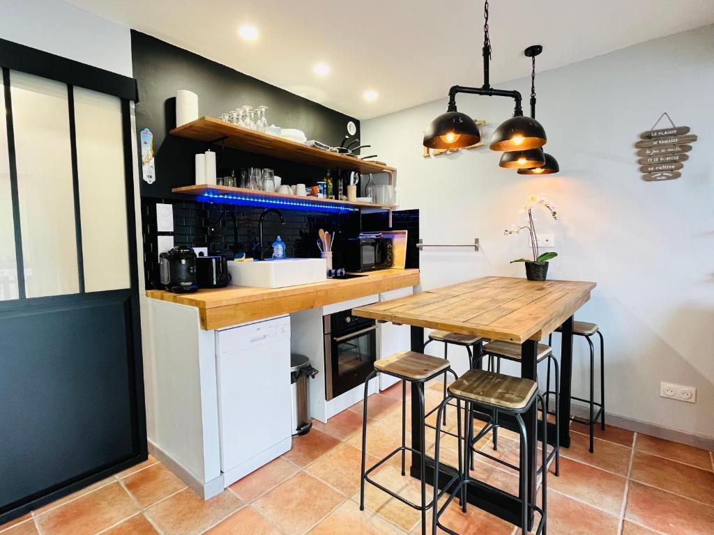 a kitchen with a counter and a table and stools at Studio moderne au pied des pistes, emplacement idéal, central et calme in Le Dévoluy