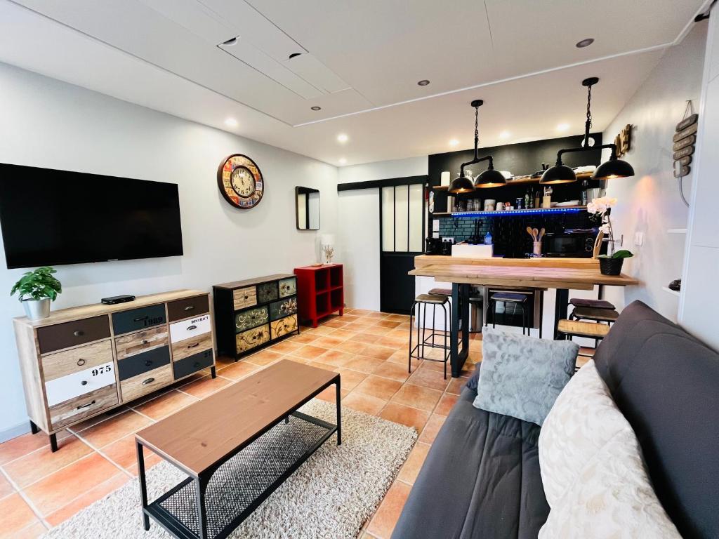 ein Wohnzimmer mit Sofa und Tisch in der Unterkunft Studio moderne au pied des pistes, emplacement idéal, central et calme in Le Dévoluy