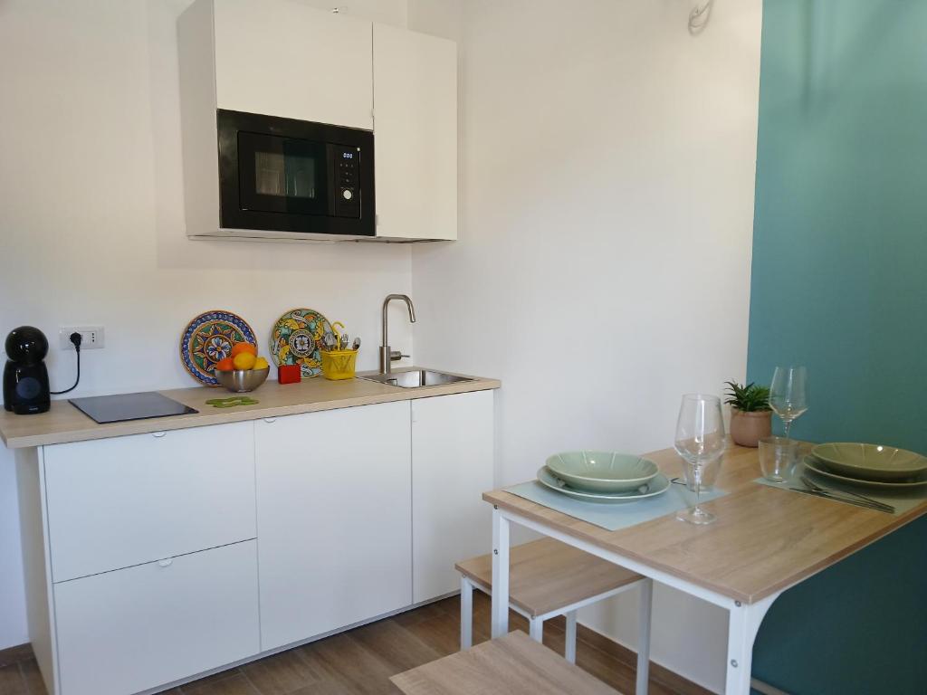 a small kitchen with a table and a microwave at Esse & Emme in Palermo