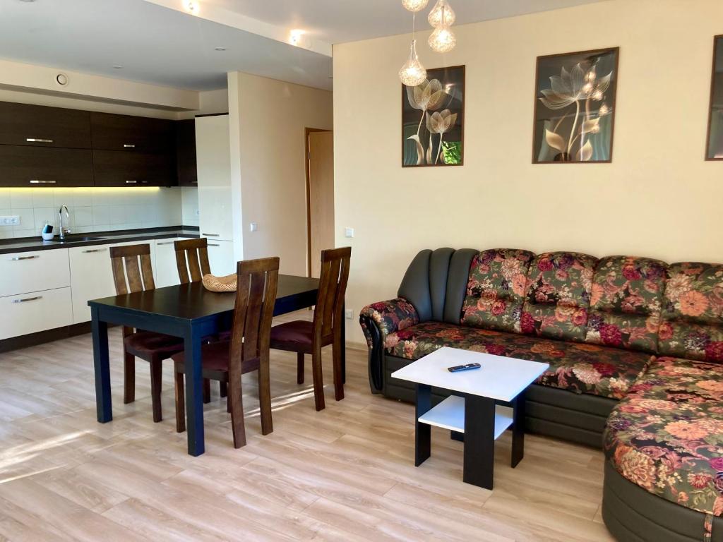 a living room with a couch and a table at Sunny Lotus Apartamentai in Druskininkai