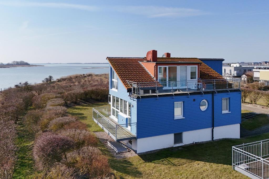a blue and white house with a view of the water at Meerkieker in Albertsdorf