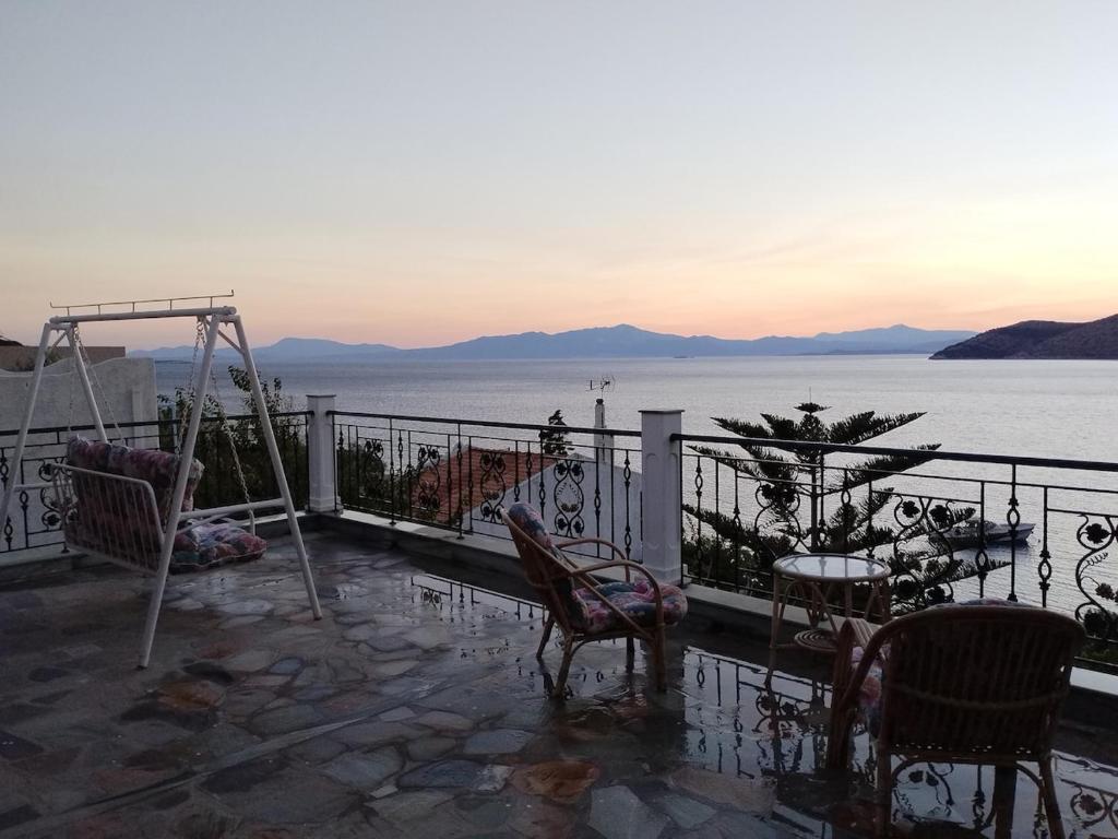 a balcony with chairs and a table and a view of the water at Ocean View Villa in Animborió
