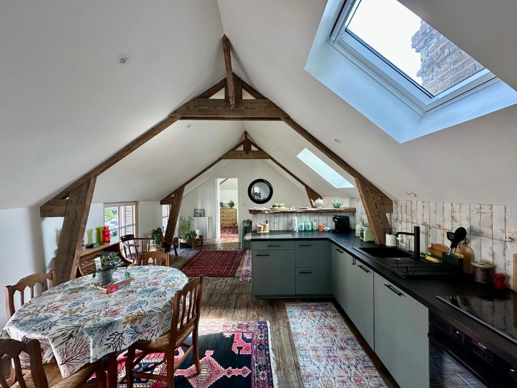 - une cuisine avec une table au milieu d'une pièce dans l'établissement L'aumônerie de Rothéneuf, à Saint-Malo